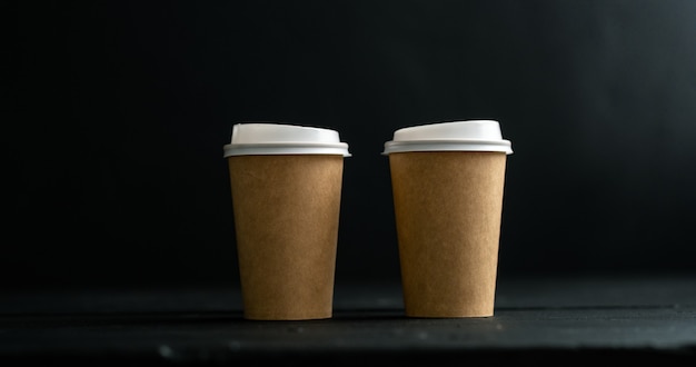 Two cups of coffee, tea, latte, cappuccino on a black background.