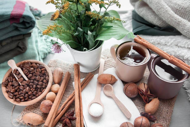 Two cups of coffee with macadamia nuts and cinnamon on a background of blankets