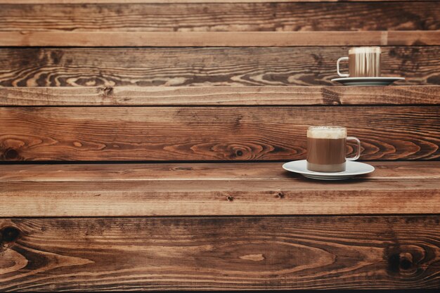 Two cups of coffee in the wooden brown terrace background. High quality photo