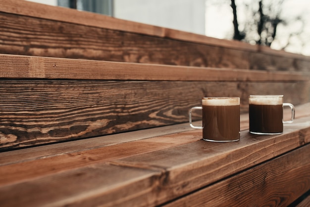 Two cups of coffee in the wooden brown terrace background. High quality photo