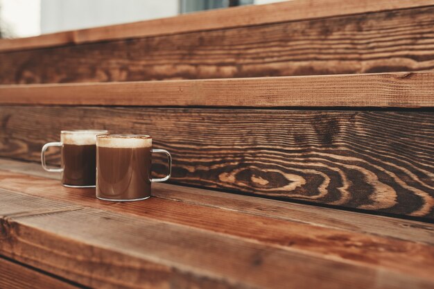 Photo two cups of coffee in the wooden brown terrace background. high quality photo