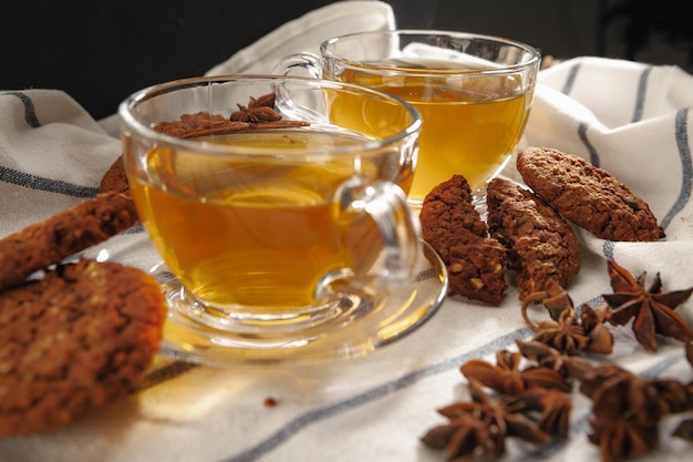 Two cups of herbal tea and cookies on kitchen cloth