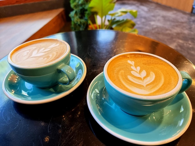 Two cups of hot latte art coffee on a table