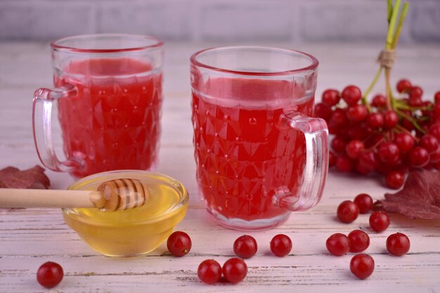 Two cups with viburnum honey. Red tea from viburnum berries.