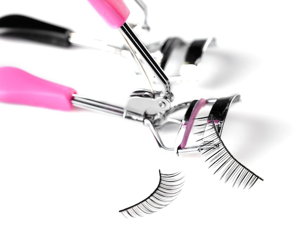 Two curlers and false eyelashes isolated on white