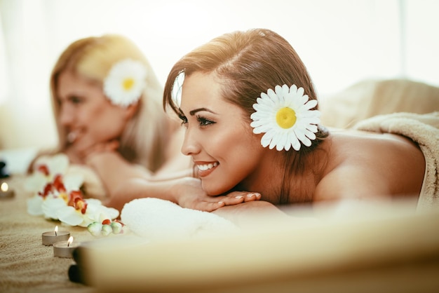 Two cute young women are enjoying during a skin care treatment at a spa.