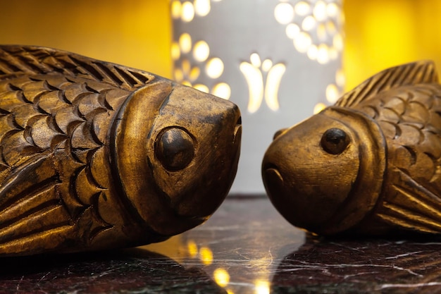 Two decorative fish carved from wood on the table