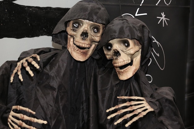 two decorative skeletons in black raincoats for halloween