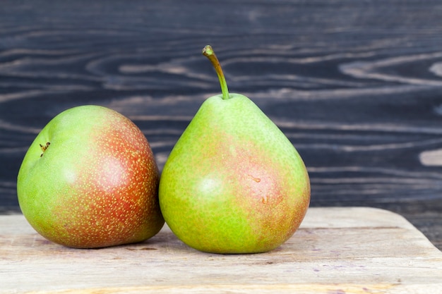 Two delicious pear on a black wooden table