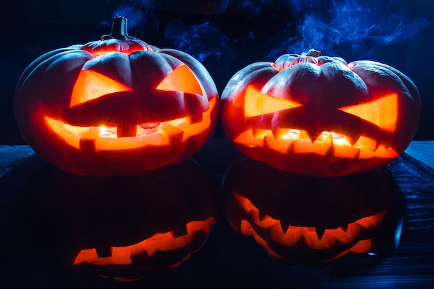 Two different Halloween pumpkins and smoke