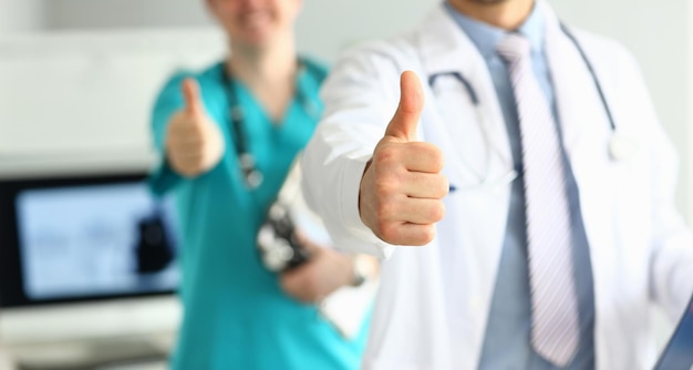 Photo two doctors show thumb up gesture with hands