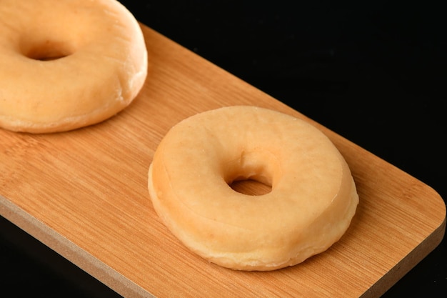 Two donuts on a wooden board