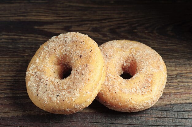 Two donuts on wooden table closeup