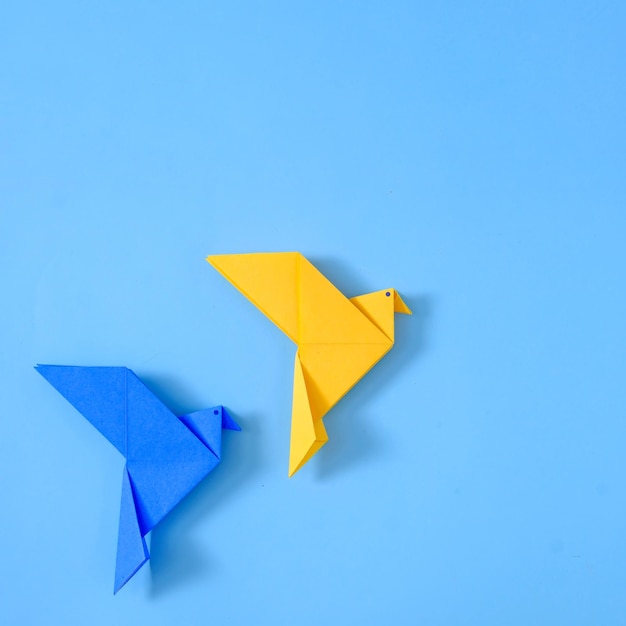 Two doves of peace on a blue background from a polygonal geometric toy origami handmade toy