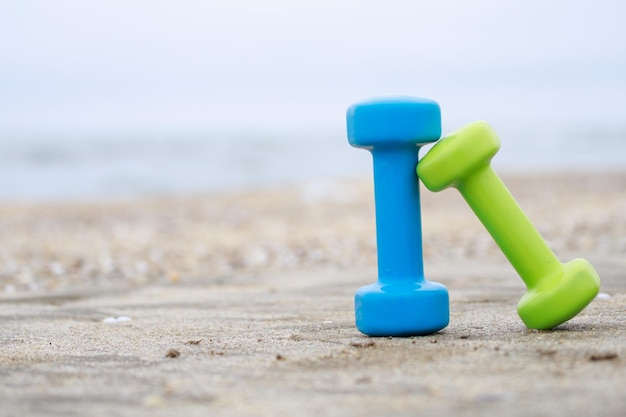 Two dumbbell on the ground at the beach High quality photo