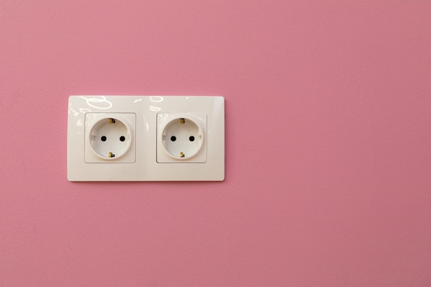 Two electrical sockets on plastered wall Copy space