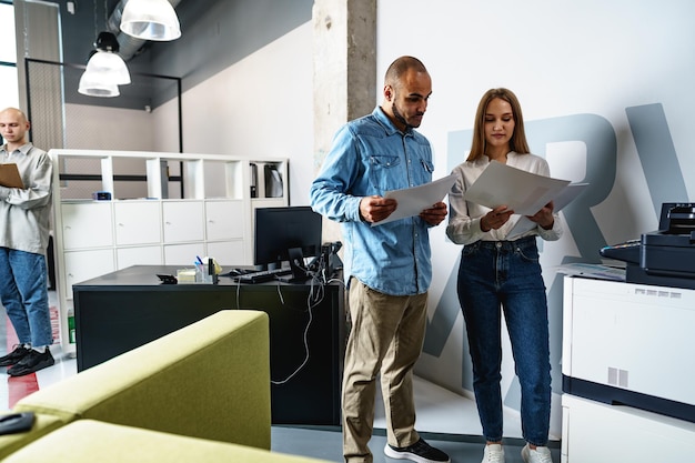 Two employees using new modern printer in office