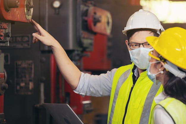 Two engineer in hard hat wearing safety using laptop for planning a project.