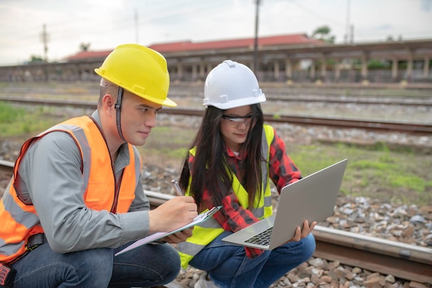 Two engineer working at train stationWork together happilyHelp each other analyze the problemConsult about development guidelines