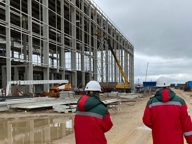 Two engineers at wind farm walking together rear view