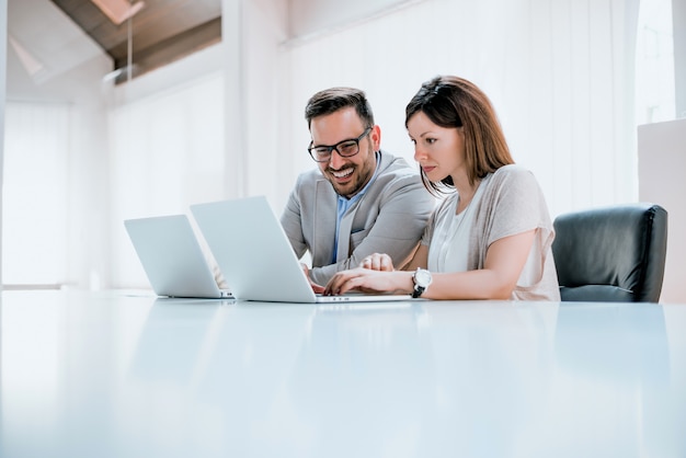 Two entrepreneurs sitting together working in an office desk