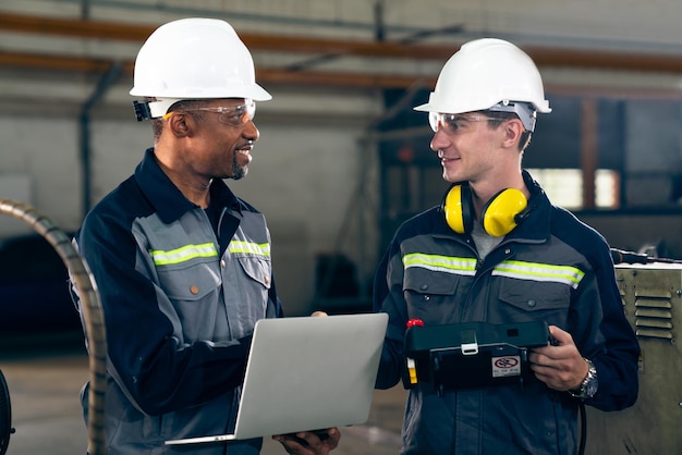 Two factory workers using adept machine equipment in a workshop