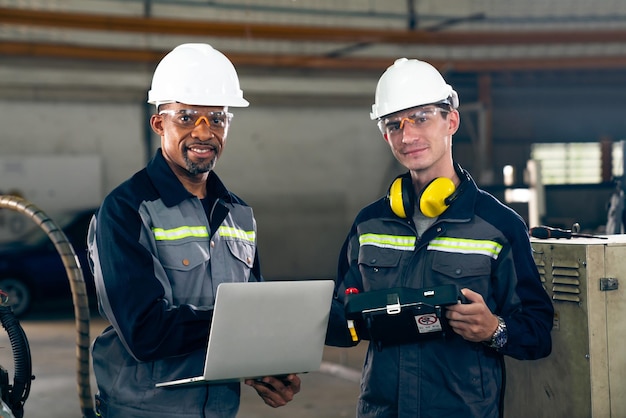 Two factory workers using adept machine equipment in a workshop