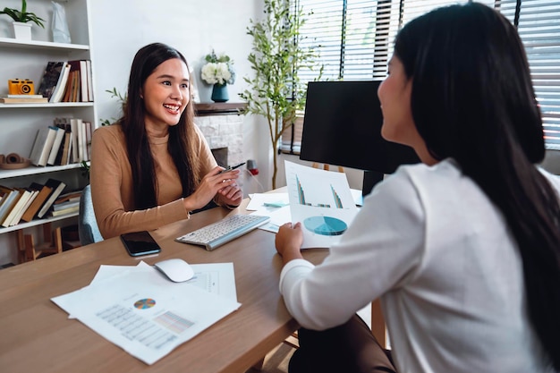 Two female accountants have a team meeting to summarize financial information in the office