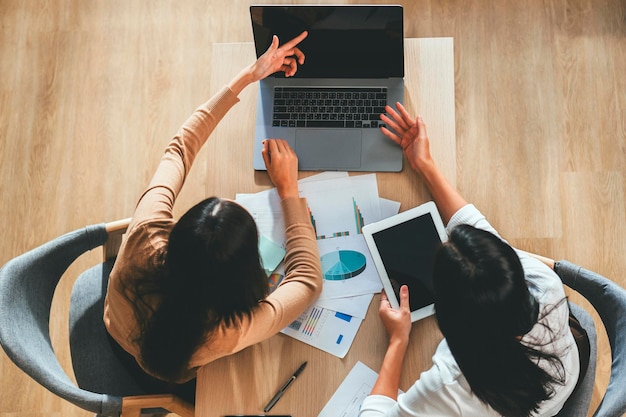 Two female accountants have a team meeting to summarize financial information in the office