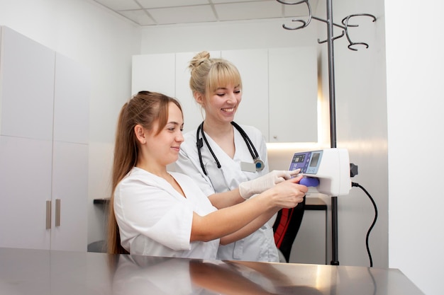 two female nurses in uniform connect infusion pump in hospital young female doctors