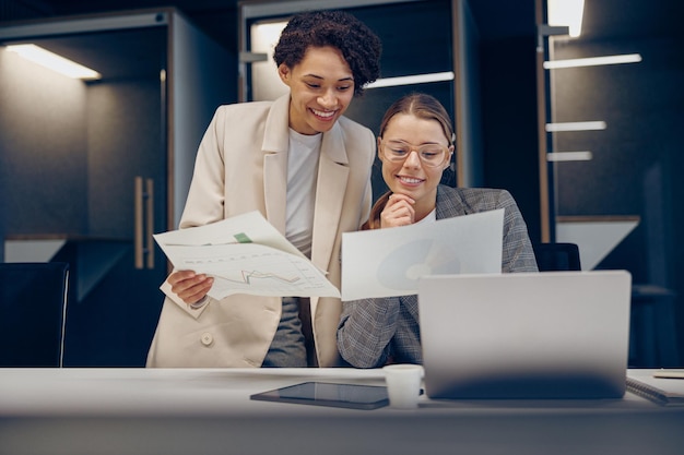 Photo two female professional executives experts discussing financial accounting papers working together