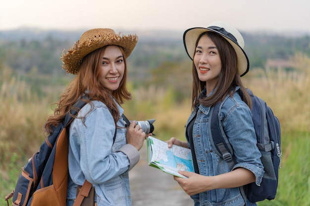 Two female tourist with backpack in countryside