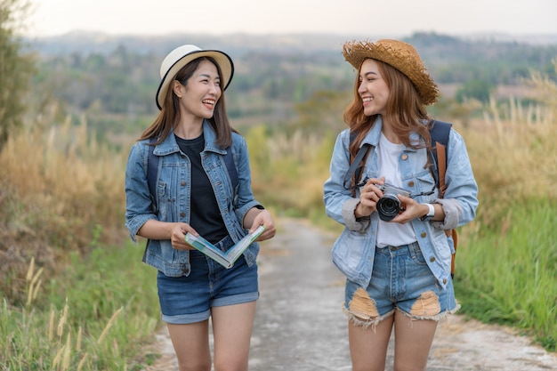 Two female tourist with backpack in countryside