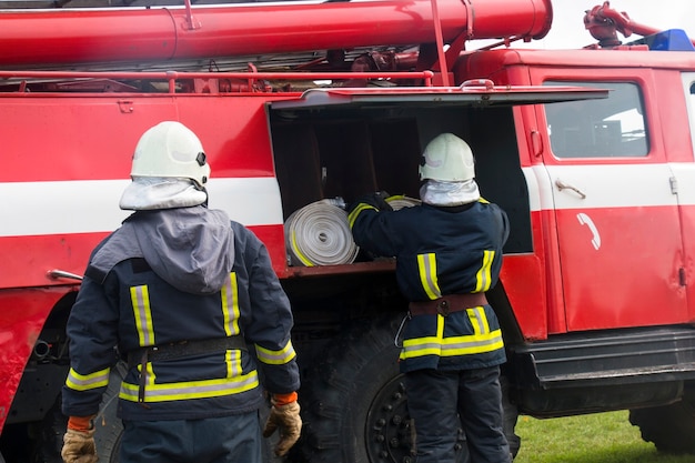 Two firemen near the fire engine