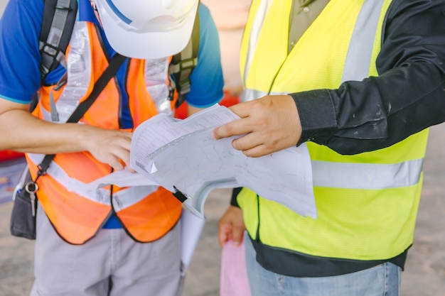 Two foreman wearing protective clothing discussion on a construction site as background