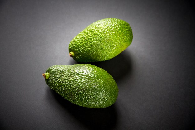 Two fresh avocados isolated on a black background