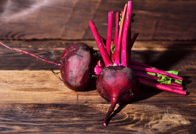 Two fresh beets on a brown wooden background