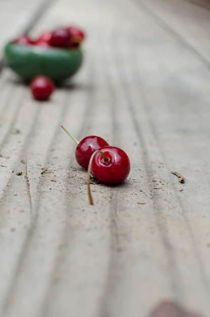 Photo two fresh cherries on wooden table outdoors