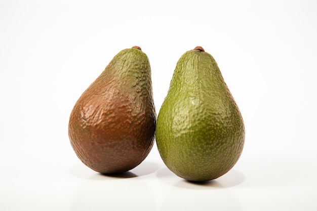 Two fresh healthy brown avocado isolated on white