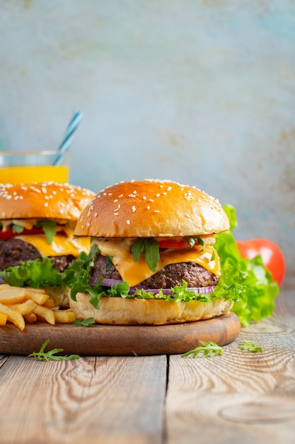 Two fresh homemade burgers with fried potatoes.