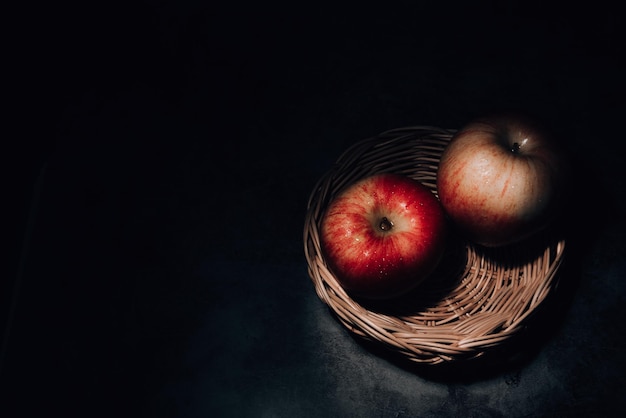 two fresh red apple with water droplets on a black background with space for text.