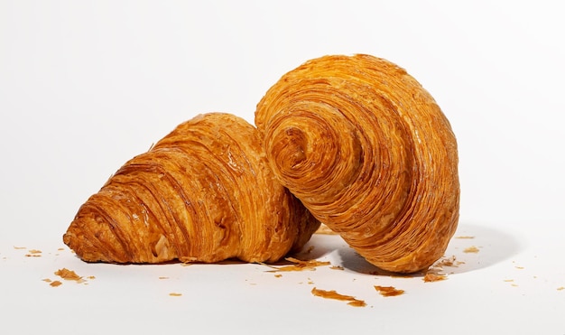 Two fresh twisted croissants French bakery composition with crumbs