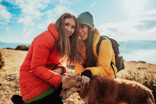 two friends are playing with a dog in nature