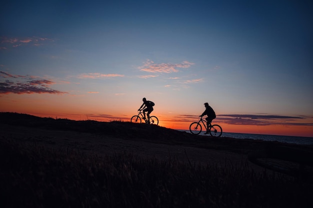 Two friends on bikes enjoy a beautiful sunset