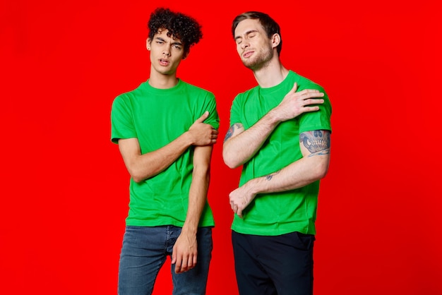 Two friends cover their hand face emotions displeasure red background