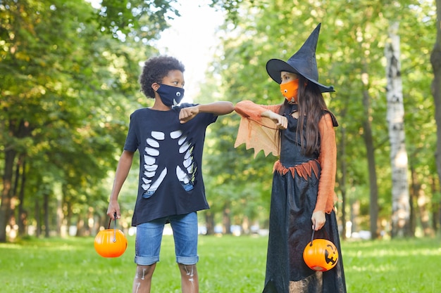 Two friends in Halloween costumes playing with each other in the park