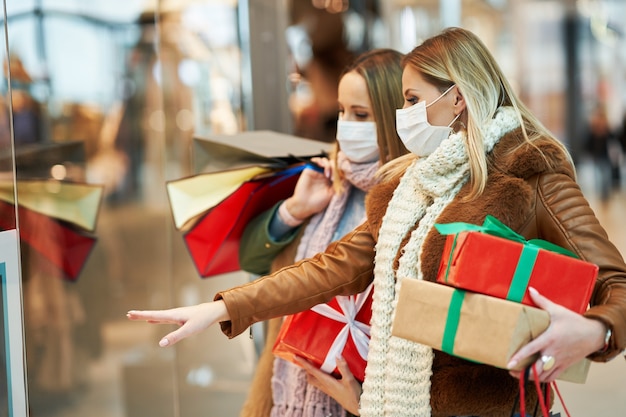 two friends shopping together wearing a mask, coronavirus concept