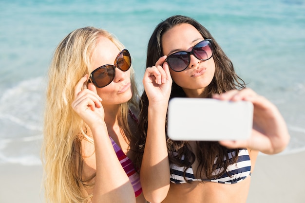 two friends in swimsuits taking a selfie