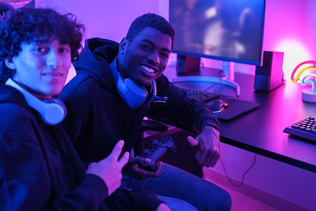 Two gamer friends together playing video games as a team and posing for the photo Concept Video games technology gaming tournament