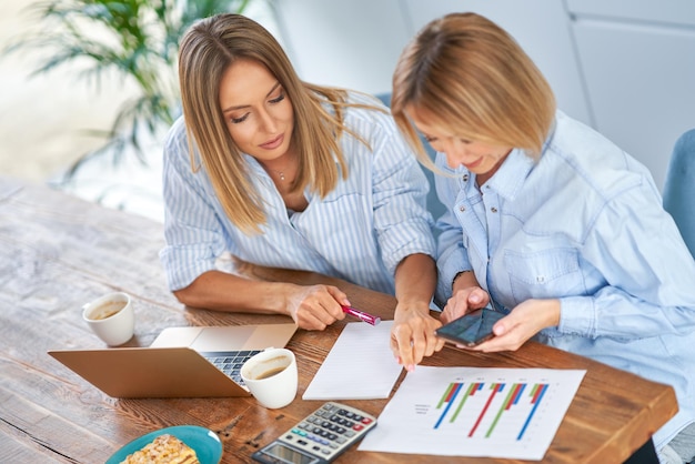 Two girl friends or lgbt couple with computer and invoice